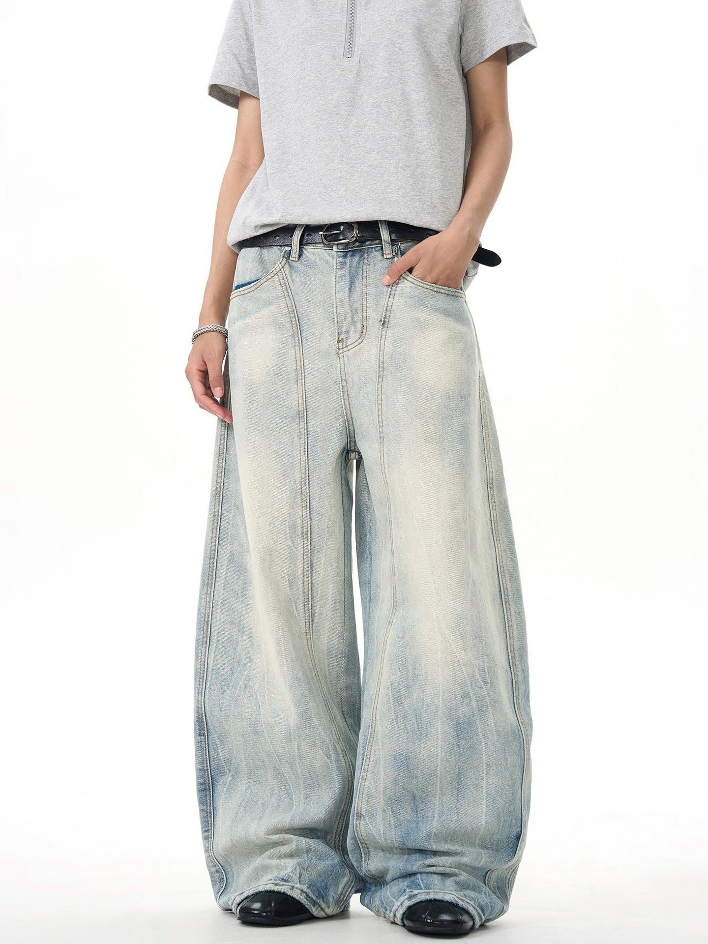 Man modeling oversized light wash wide-leg jeans and grey zip polo, Vaezion streetwear style