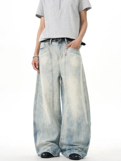 Man modeling oversized light wash wide-leg jeans and grey zip polo, Vaezion streetwear style