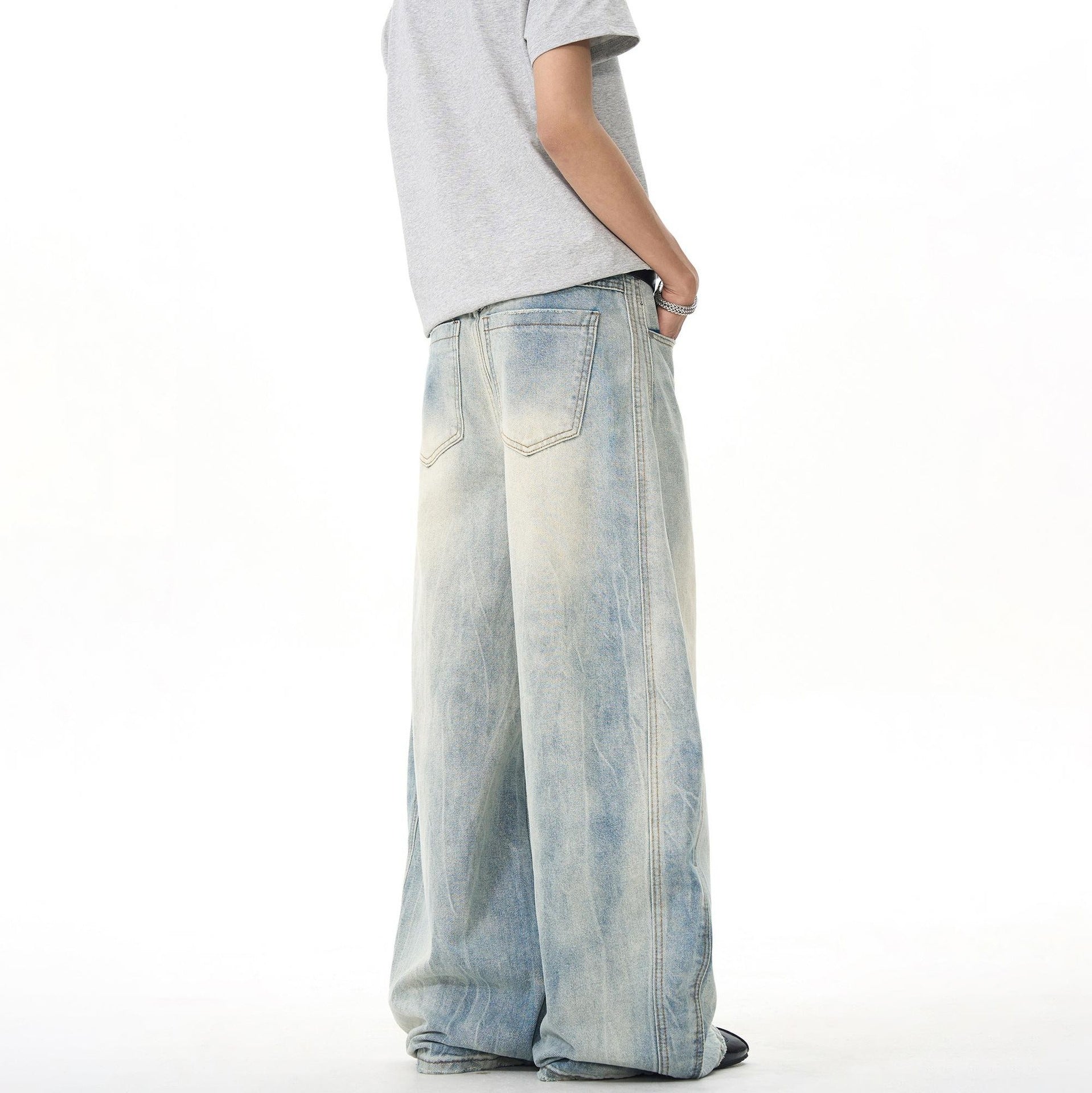 Man wearing wide-leg faded denim jeans and grey t-shirt, streetwear style, Vaezion Shop