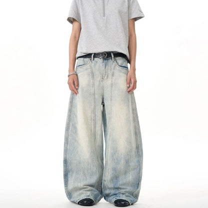 Man wearing oversized wide-leg faded jeans and gray t-shirt, streetwear style from Vaezion Shop